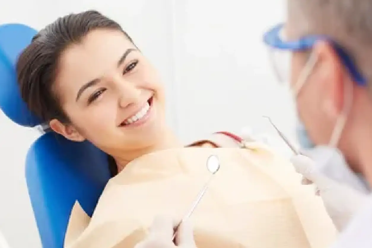 A woman sitting in the dentist chair smiling.