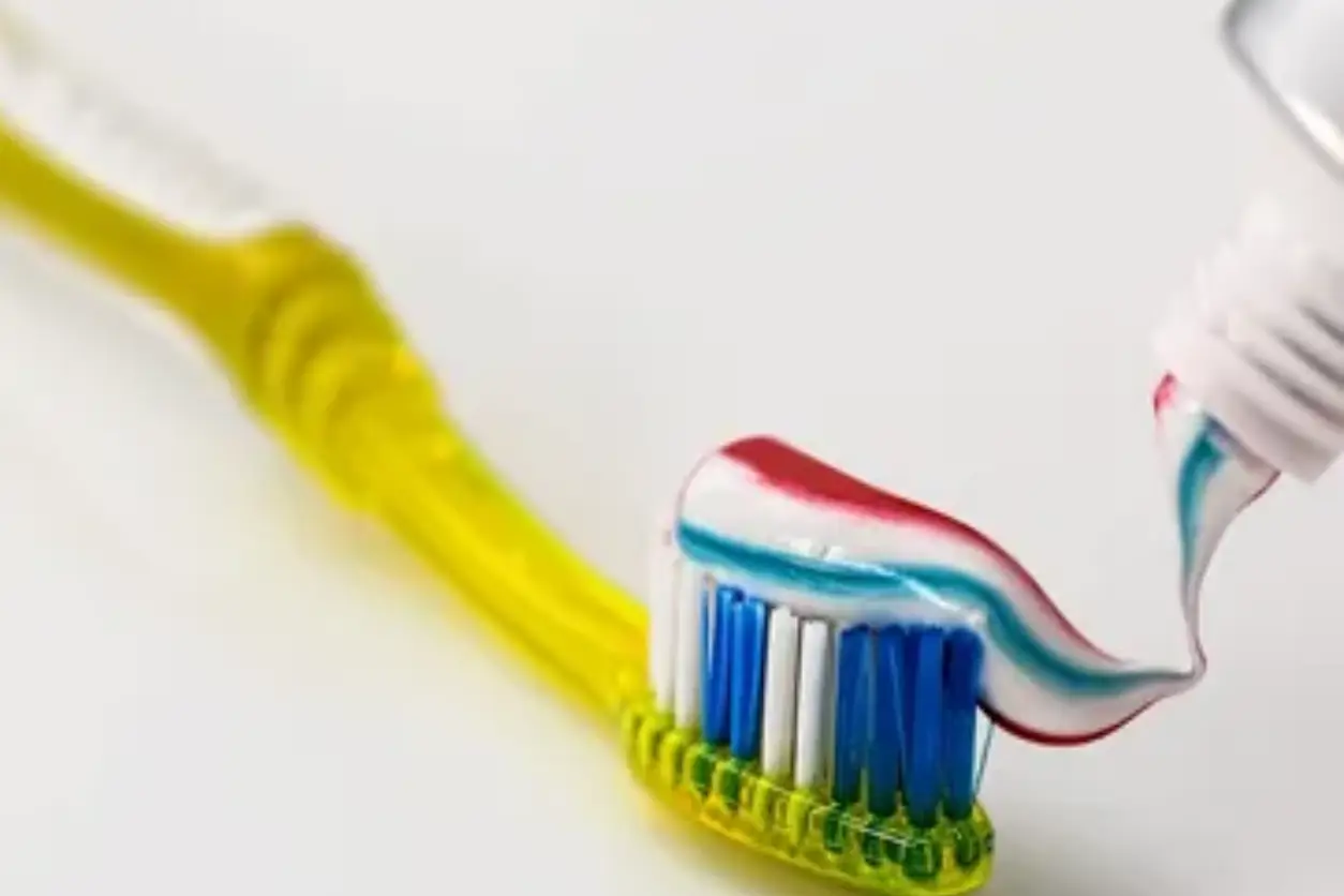 A toothbrush with toothpaste on it is sitting next to the tooth paste.